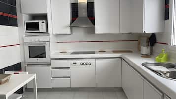 A modern kitchen with white cabinetry, a built-in microwave, a stove, and a dishwasher.