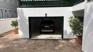 A car parked inside a garage with a white wall and green trim.