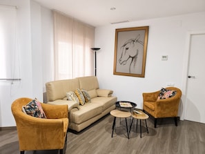 A living room with a sofa, two armchairs, a coffee table, and a floor lamp.