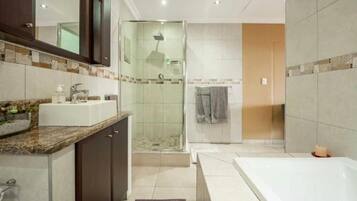 Une salle de bain moderne équipée d’une douche, d’une baignoire et d’un meuble-lavabo avec un évier.