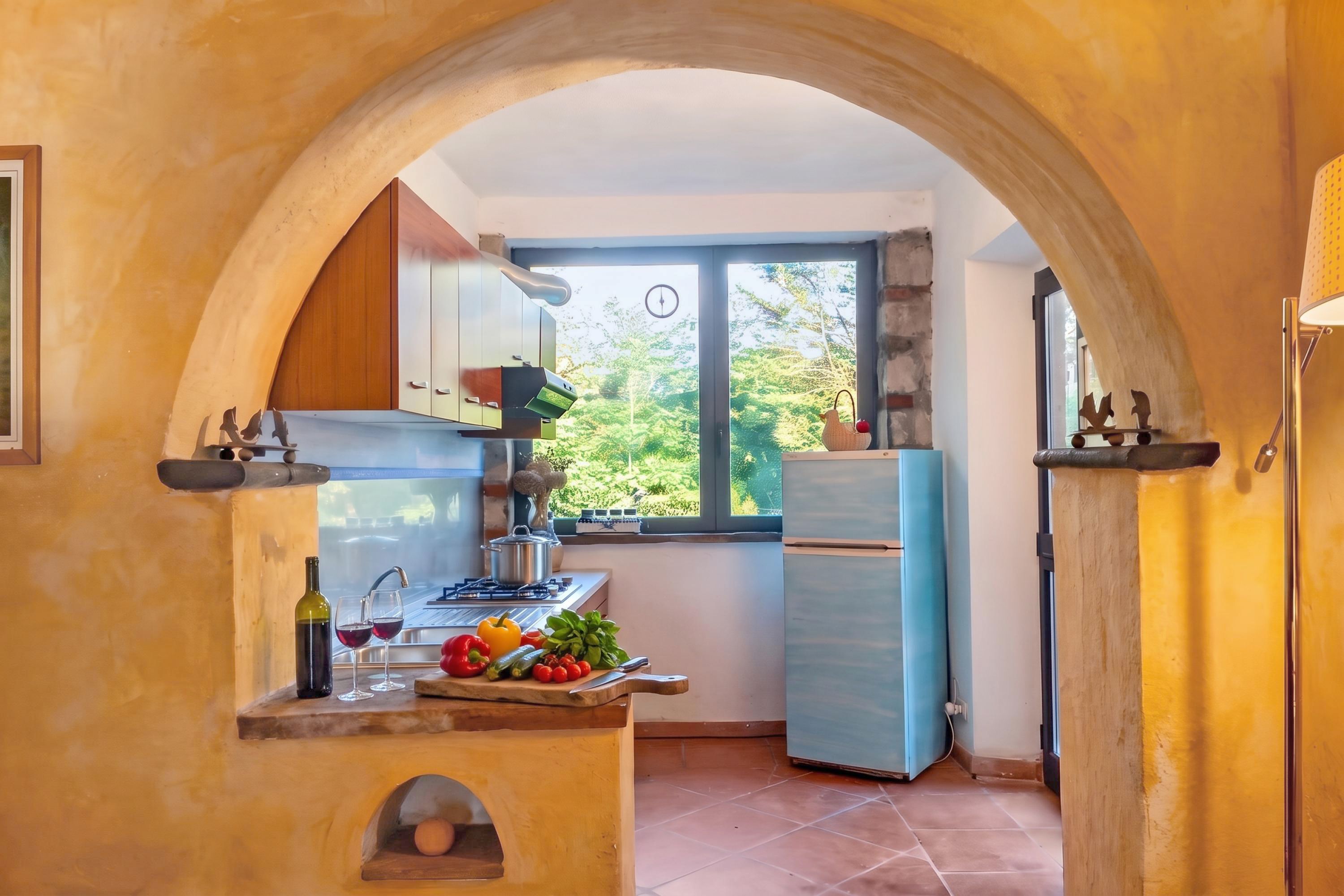A kitchen with a window, a stove, a refrigerator, and a sink.