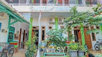 A hotel with a balcony, a sign that reads 'HOTEL TIRKEN,' and a sign that says 'ASY.'