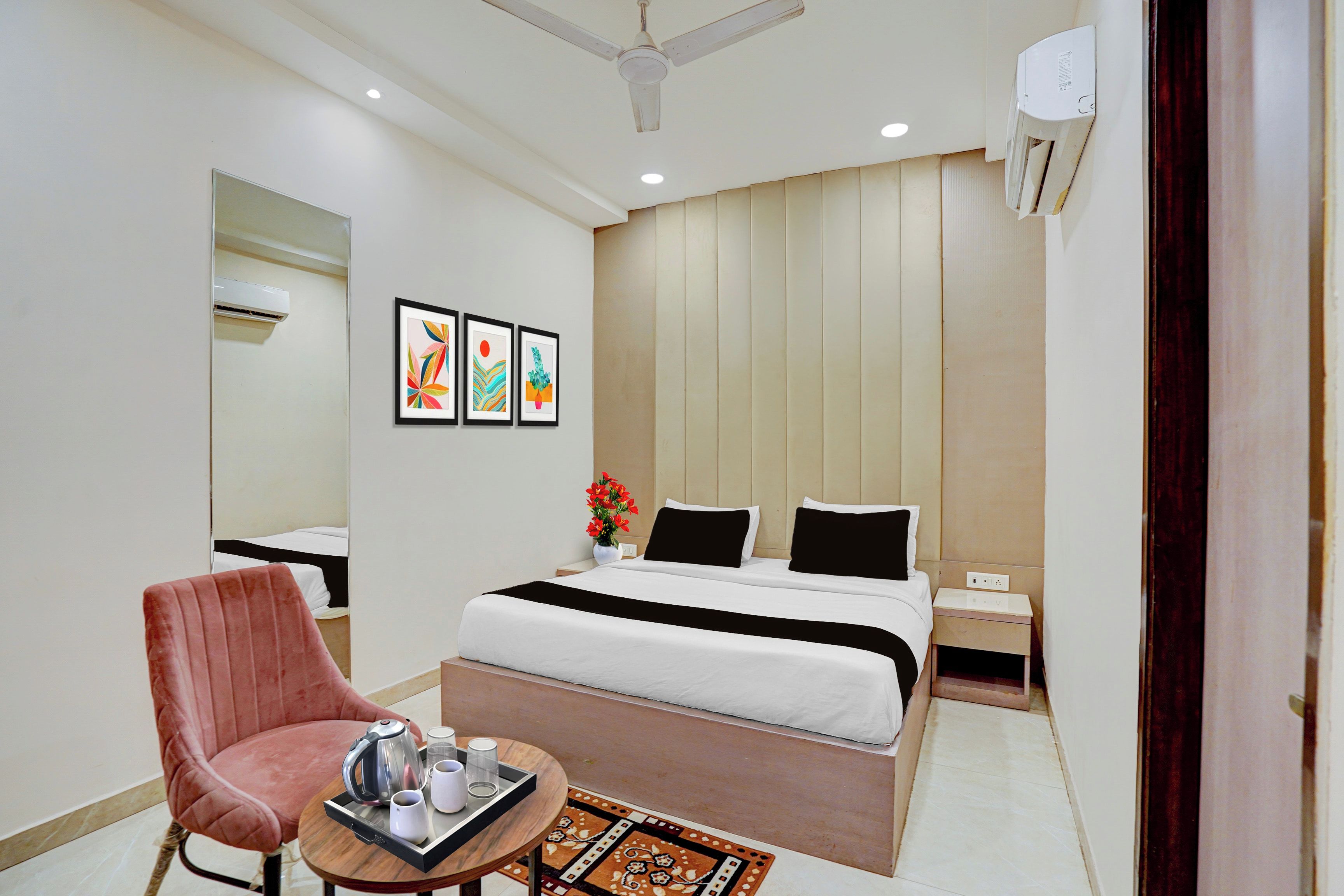 Une chambre d’hôtel avec un lit, une table de chevet, une chaise et une œuvre d’art au mur.