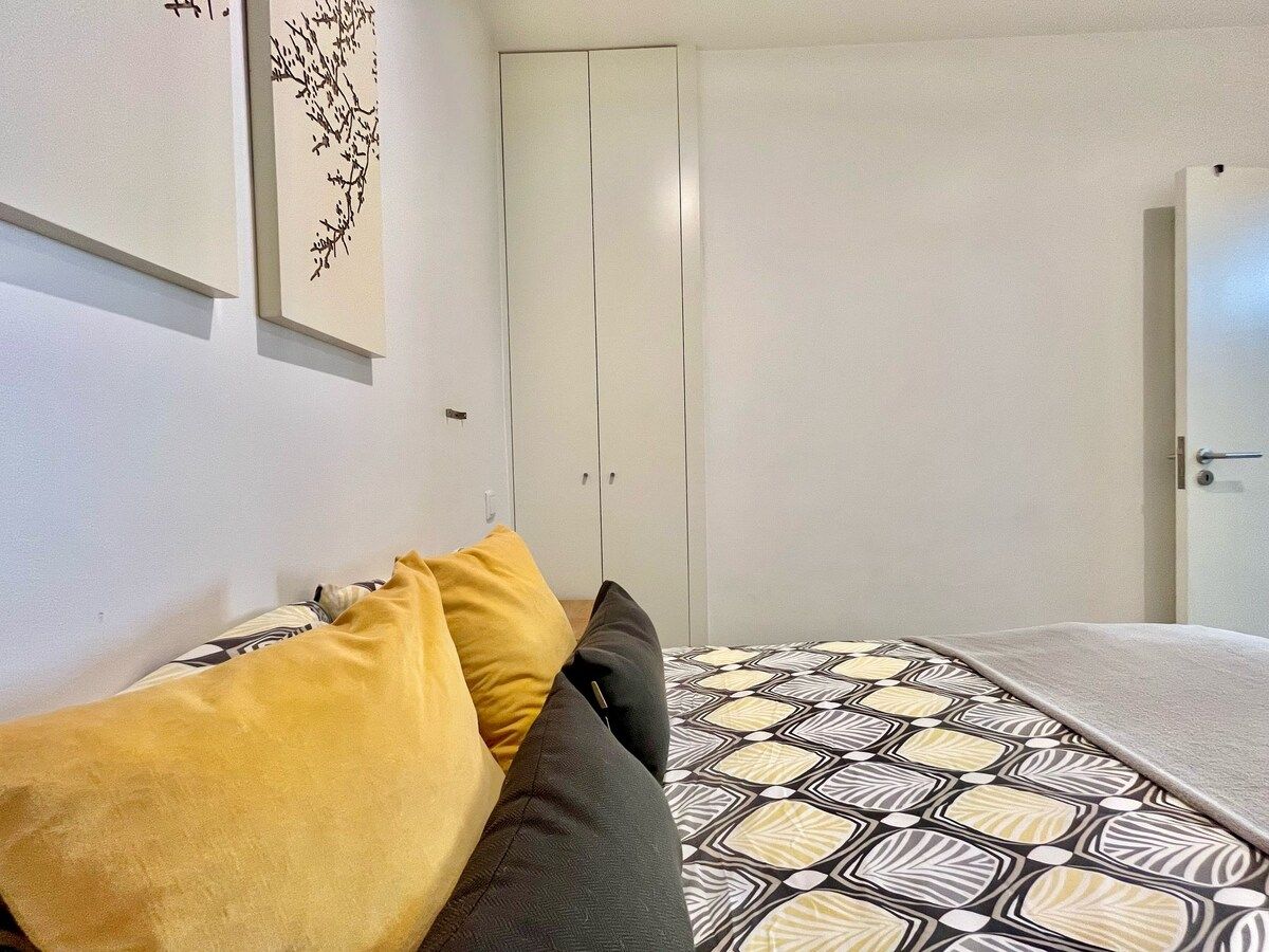 A bedroom with a bed, a wardrobe, and a door.