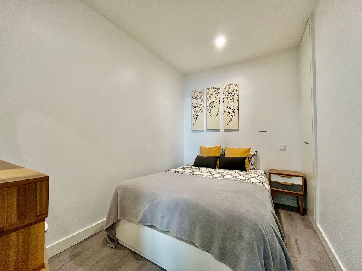 Une chambre à coucher avec un lit, une table de chevet et une commode.