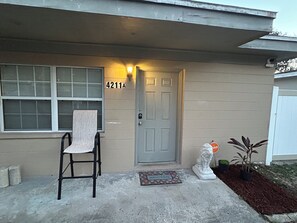 A residential house with a grey door, a mailbox, a welcome mat, and a small garden with a statue. - The Haven - Cozy 1 bedroom apt near Busch Gardens and minutes from Tampa venues (Tampa)