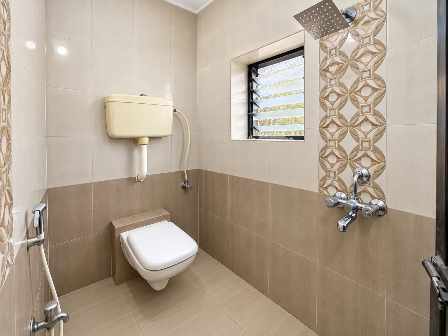 Un baño con inodoro, ducha y ventana.