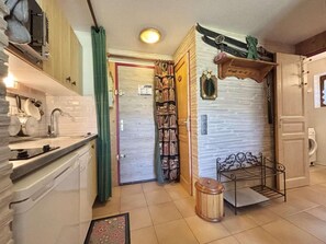 A compact kitchen with a sink, cabinets, and a small dining area with a bench. - Ground floor, tv, ski locker, 24m², Praz sur Arly (Praz-sur-Arly)