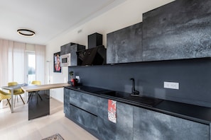 Una cucina moderna con un piano di lavoro nero, un forno a microonde integrato e un lavello.