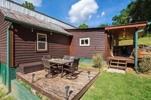 A wooden house with a deck, outdoor seating, and a covered area. - Cozy 3BR Mountain Cabin | Peaceful & Relaxing (Murphy)