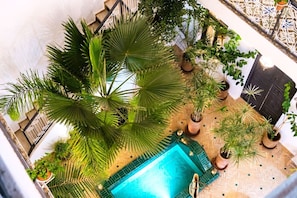 An outdoor area with a swimming pool, surrounded by potted plants and a staircase. - Riad Des Sables • Pool • 15 min walk Jemaa El Fna (Marrakesh)