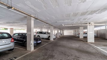 Garagem de estacionamento em vários níveis, com pilares de concreto e uma grade de vagas.