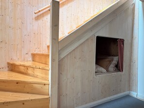A wooden staircase with a small window at the top. - Teestuuv - Cozy 60 square meters for 2 people in the heart of Husum (Husum)