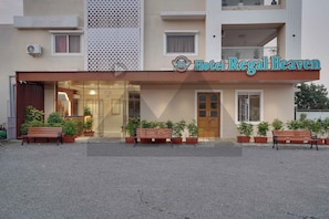 Un hotel llamado 'Hotel Regal Heaven' con una fachada moderna, amplias ventanas y terraza.
