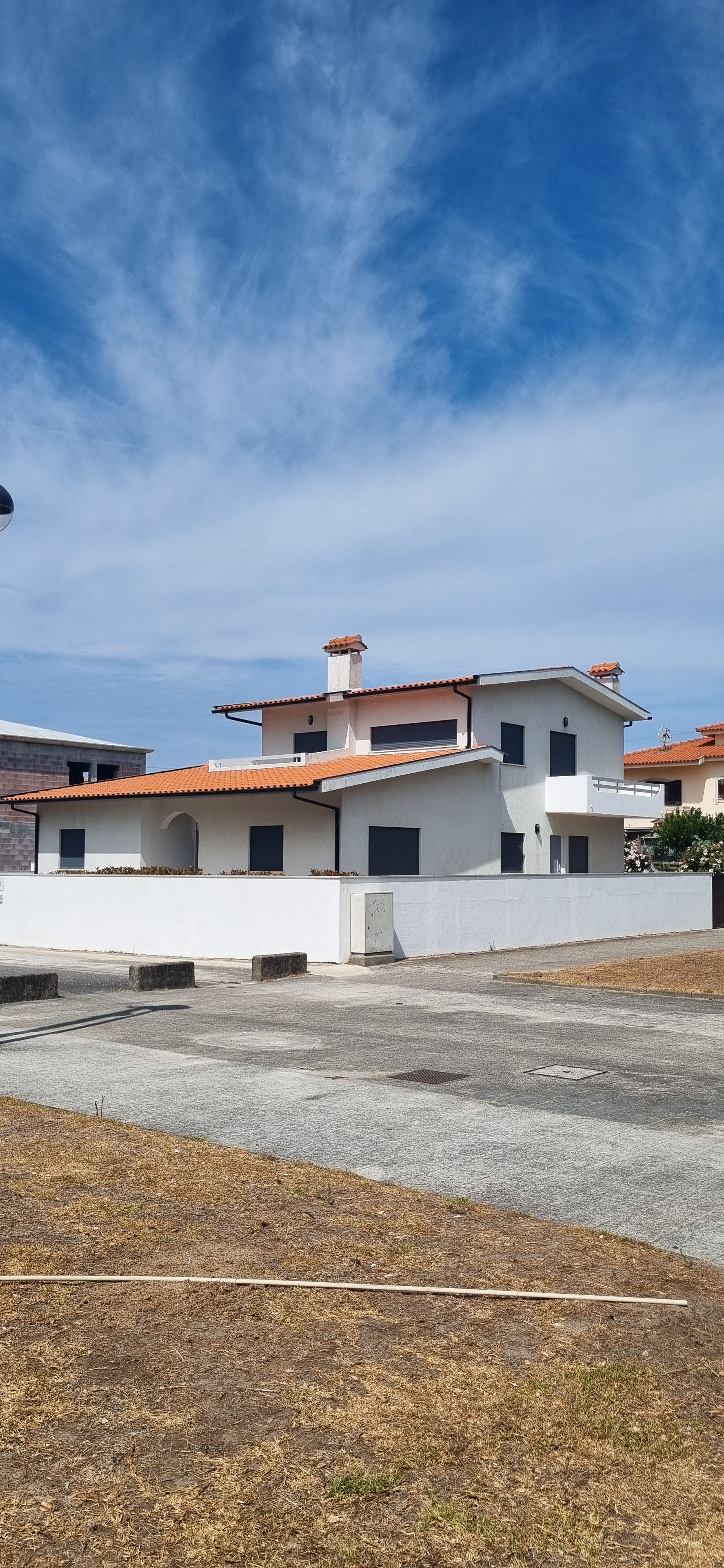 A residential building with a flat roof, multiple windows, and a visible chimney.