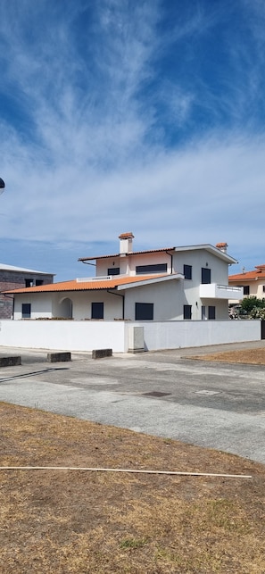 A residential building with a flat roof, multiple windows, and a visible chimney. - House 'Casa Casais' with private terrace, private garden and Wi-Fi (Chafé)