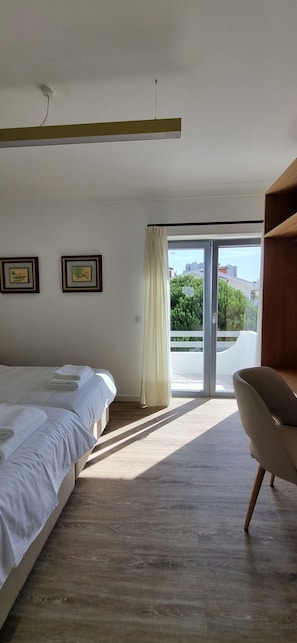 A modern bedroom with a bed, a chair, and a view through a large window. - House 'Casa Casais' with private terrace, private garden and Wi-Fi (Chafé)