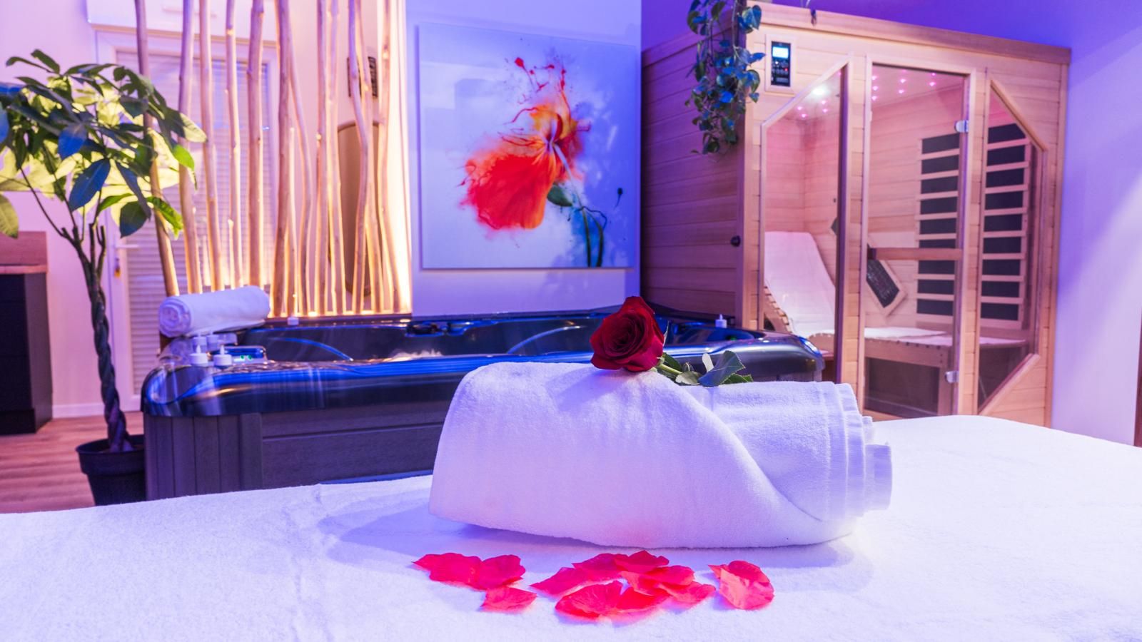 Un cuarto de spa con una camilla de masaje, una sauna y un cuadro en la pared.