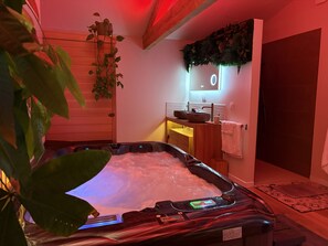 A hot tub with a control panel, a wooden bench, a sink with a mirror, and a towel rack. - Luxury Provence Suite – Private Pool, Hot Tub & Sauna (Cabannes)