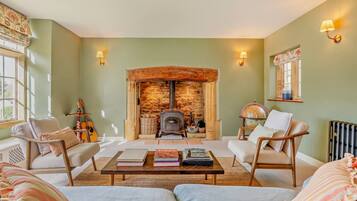 Principle living room with inglenook fireplace and wood-burning stove