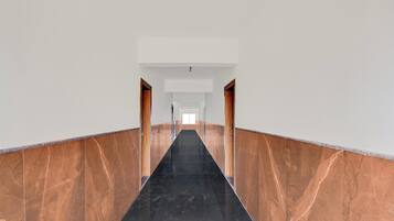 A corridor with marble walls and a black floor.