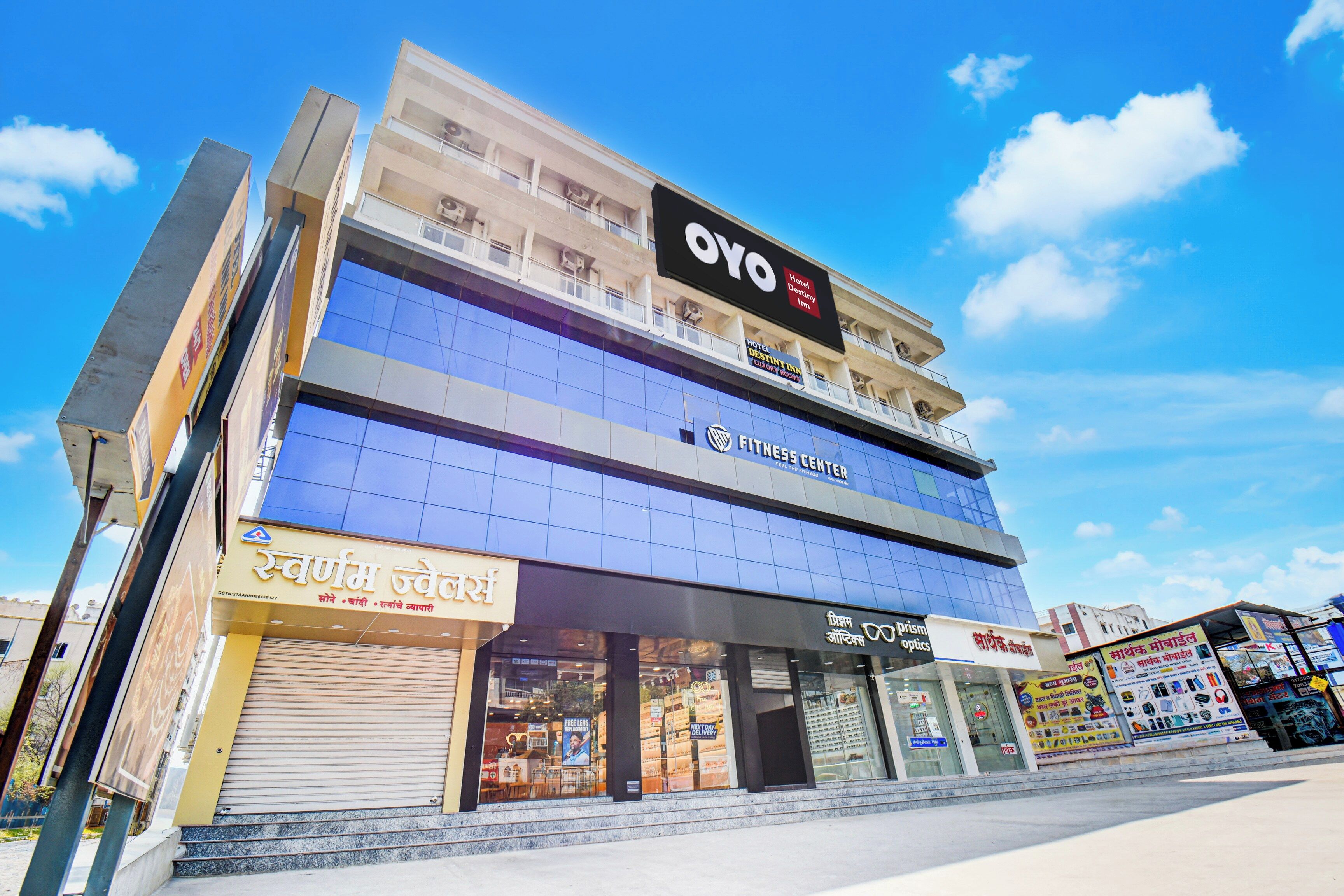 A multi-story building with a fitness center on the ground floor, a hotel named OYO on the second floor, and various shops on the ground floor.