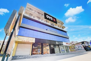 A multi-story building with a fitness center on the ground floor, a hotel named OYO on the second floor, and various shops on the ground floor. - Super Hotel O Destiny Inn (Pune)
