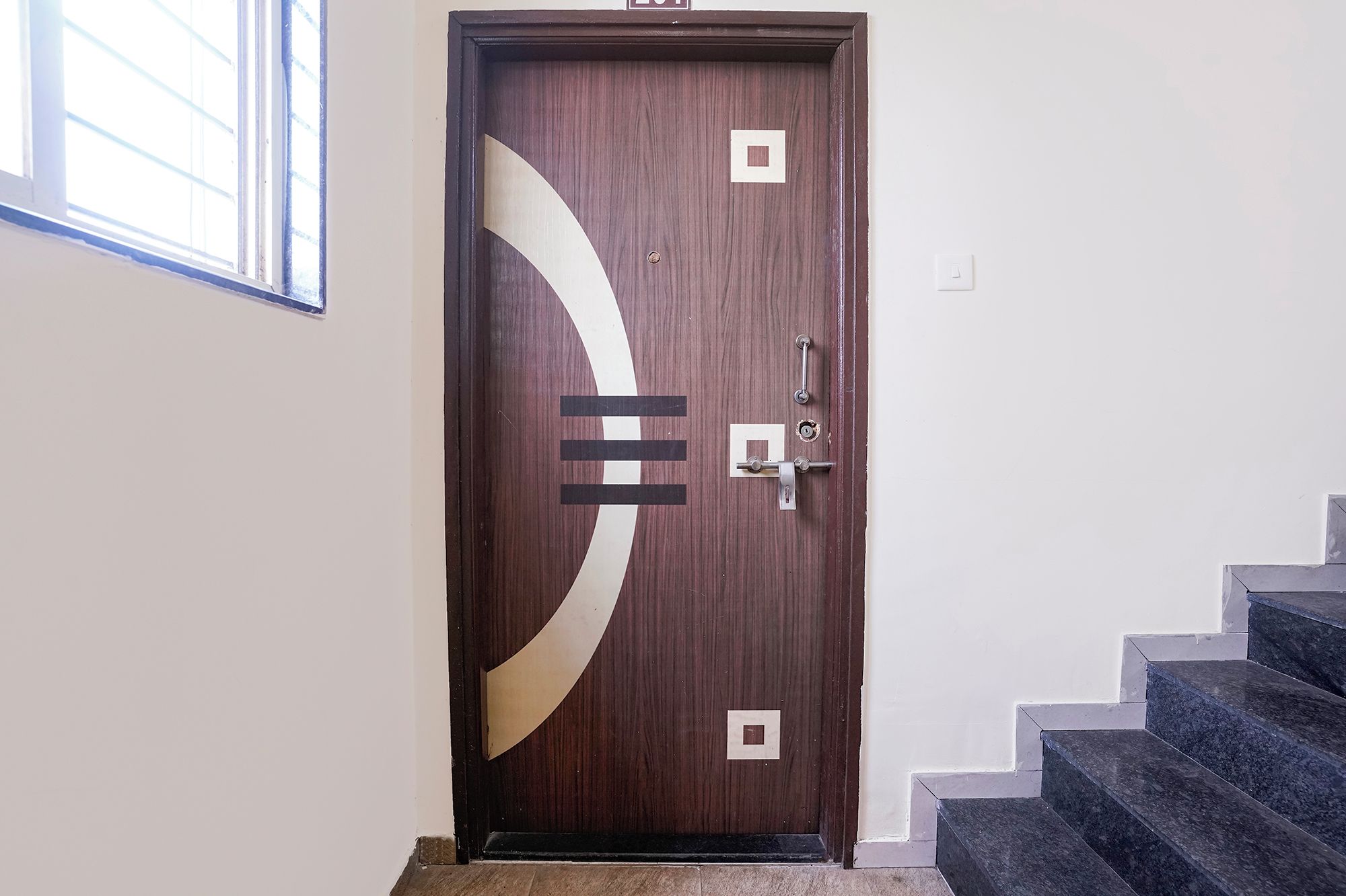A wooden door with a modern design, a keyhole, and a lock.