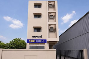 A multi-story building with a sign for 'fab hotels' and a modern architectural design.
