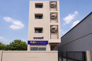 Un edificio de varios pisos con un letrero que dice 'fab hotels' y un diseño arquitectónico moderno.