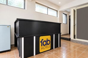 A reception desk with a 'fab hotels' sign, a door to a room, and a window with a view.