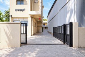 A building with a beige facade, a black metal gate, and a clear sky.
