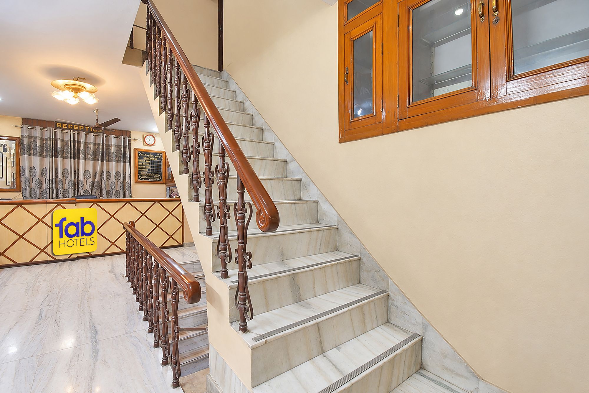 A hotel staircase with marble steps and wooden railings.