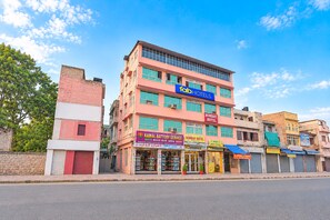 Un edificio de varios pisos con letreros que indican 'Bombay Hotel' y 'Fab Hotels'.