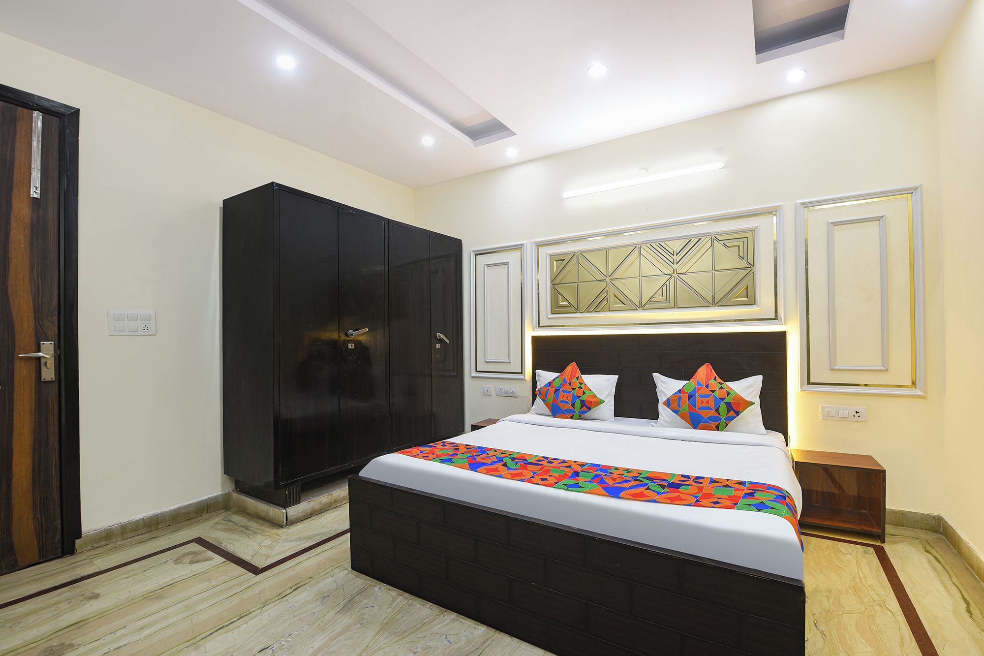 Habitació d'hotel amb llit, armari i un panell decoratiu a la paret.
