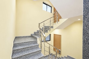 A multi-level interior with a staircase, a door, and a window.