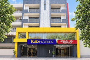 Entrada de hotel com um letreiro grande 'fabHOTELS' e a identificação 'GOLDEN KEY RESIDENCY'.