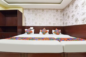 Ein Hotelzimmer mit einem großen Bett, einem Holzschrank und blumigem Wandpapier.