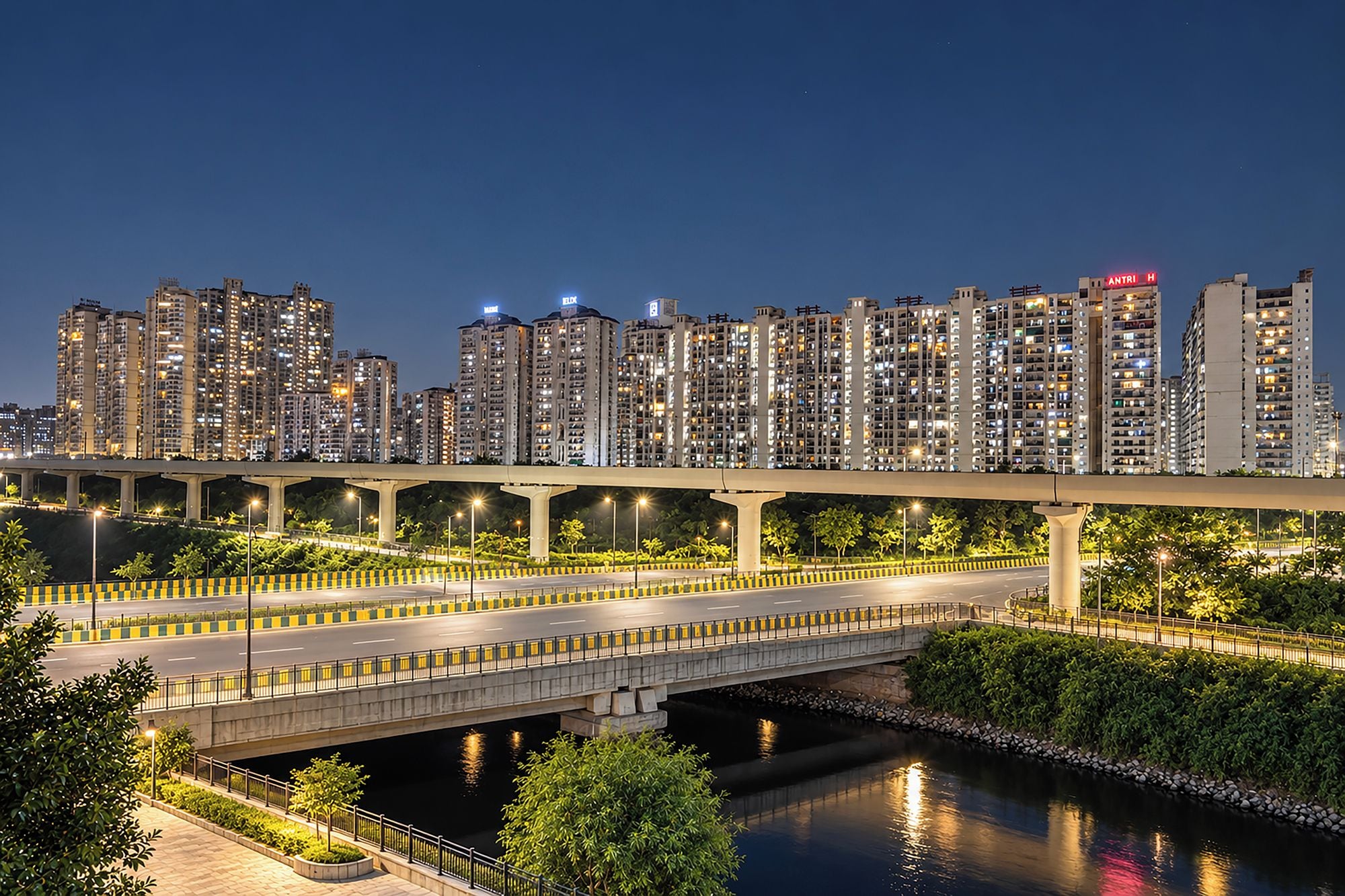 A nighttime cityscape with high-rise buildings, a bridge, and a river.