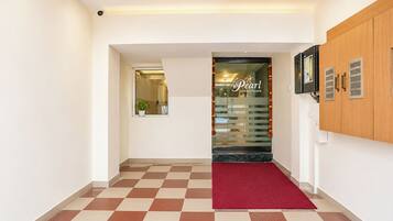 A hotel lobby with a checkered floor, a red carpet, and a reception desk.
