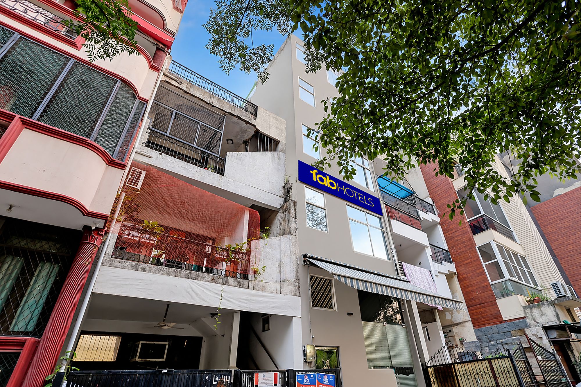 A multi-story building with a visible 'fab hotels' sign, balconies, and a mix of architectural styles.