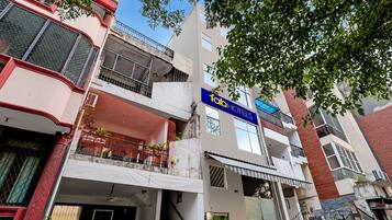 A multi-story building with a visible 'fab hotels' sign, balconies, and a mix of architectural styles.