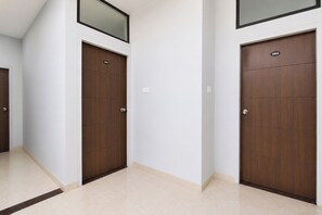 A hallway with two wooden doors, each marked with a number. - FabHotel Fortune Tulsi Nagar (Indore)