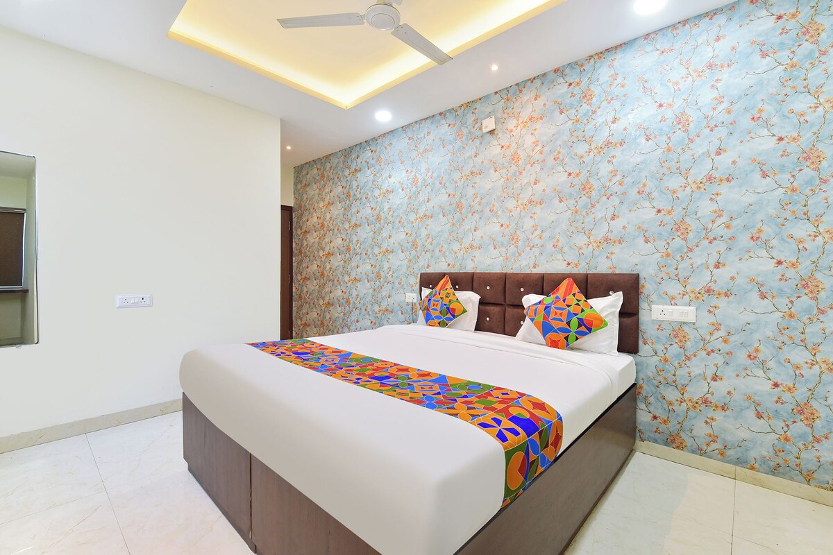A bedroom with a bed, a ceiling fan, and a floral wallpaper.