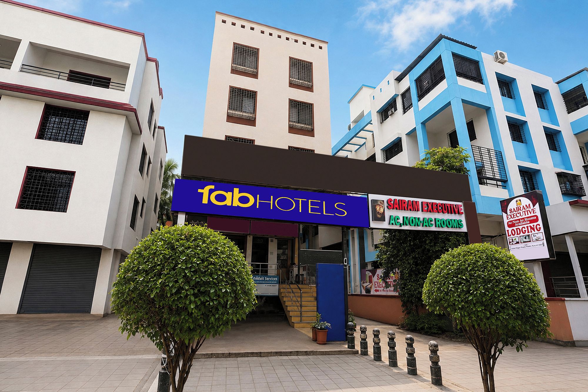 Un hotel llamado 'fab hotels' con un cartel que indica 'Sairam Executive' para habitaciones sin aire acondicionado.