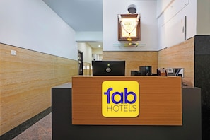 Una recepción de hotel con una computadora Dell y una foto enmarcada encima.