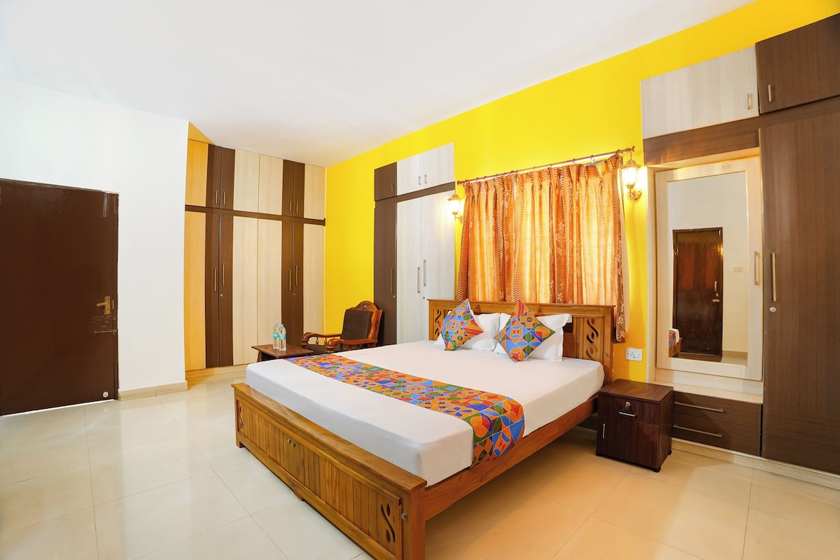A bedroom with a bed, bedside tables, a wardrobe, and a mirror.