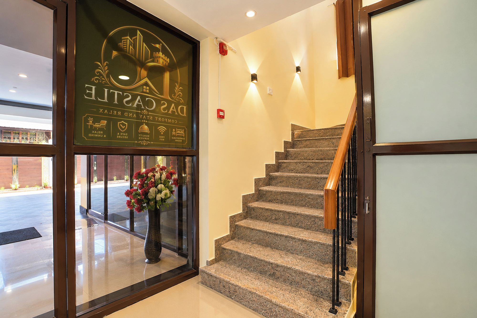 A hotel entrance with a staircase leading to the upper floor.