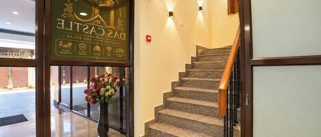 Entrada de un hotel con una escalera que lleva al piso superior.