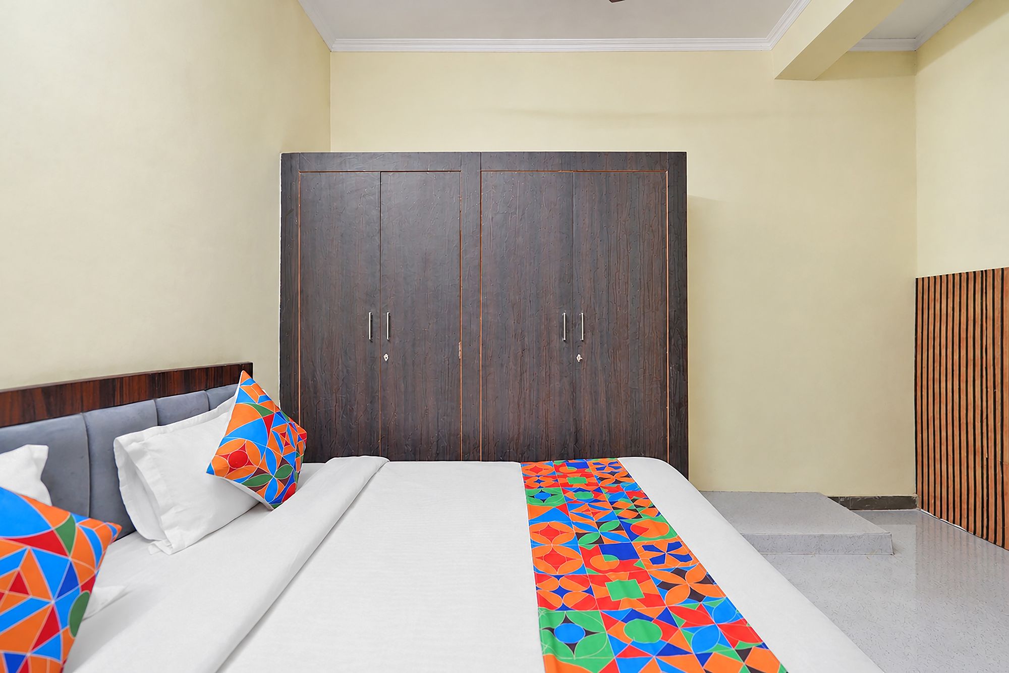 Habitación de hotel con cama, armario y una pequeña escalera.